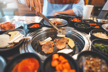 Korea bbq style restaurant  grilling with meat and vegetable side dish