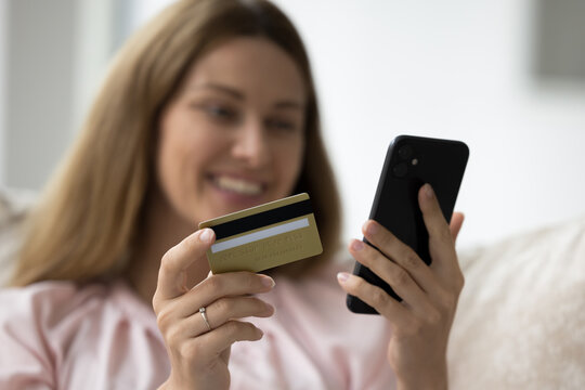 Close up shot woman hold credit card and smartphone, female client pay use secure banking service, enter information, enjoy electronic shopping, ordering goods through webstore, doing on-line payment