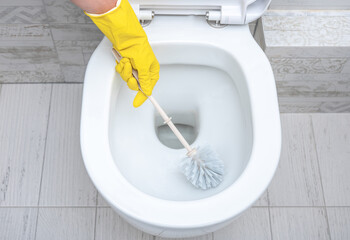 cleaning wc. Housekeeper, cleaning man at toilet. Brush up Toilet for cleanliness and hygiene....