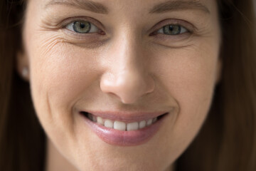 Cropped close up part of female face front view, young 30s woman portrait look at camera, having...