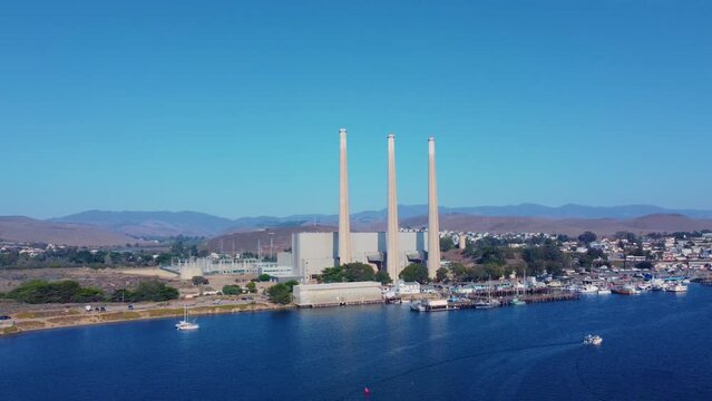 Drone shot a Power station in Morro Bay harbor with a sea view and mountains in the background