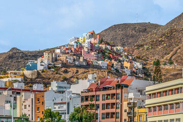 Bottom view from Santa Cruz de Tenerife on a city with multi-colored bright buildings among the mountains, Spain. Beautiful hillside town in the Canary Islands