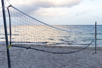 filet de volley-ball installé sur la plage en bord de mer lors d'un lever de soleil