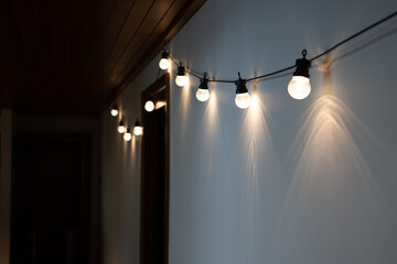 Festoon lights hanging on wall of mid-century house - 547597007