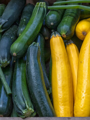 Fresh raw green and yellow Courgettes (Zucchini) on a greengrocer's stall at a food market