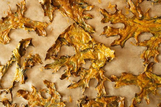 Looking down at freshly baked Khale chips covered in nutritional yeast.