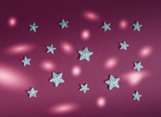 Decorative silver stars and circles of light on dark red background