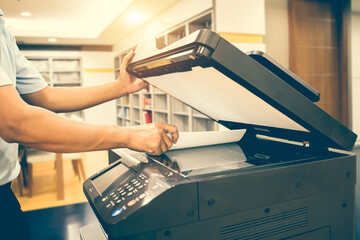 Photocopier printer, Close up hand scanning paper on the copier or photocopy machine concept of office workplace equipment for scan document or printing or Xerox a sheet. - obrazy, fototapety, plakaty
