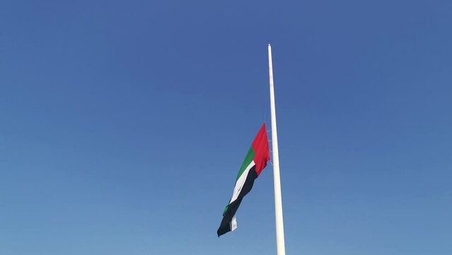 Lowering the United Arab Emirates flag. A raised flag on a flagpole is half-mast in the event of officially declaring a national mourning day.
