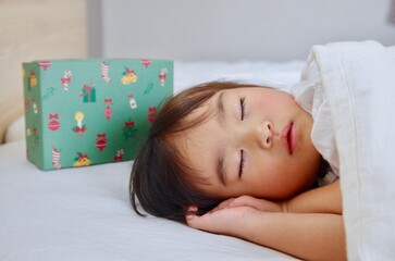 寝ている女の子の枕元にサンタさんからのプレゼント