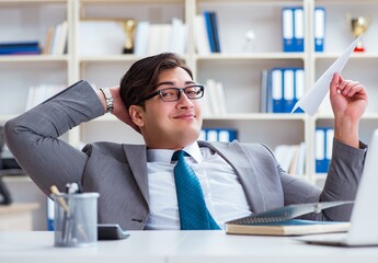 Businessman with paper airplane in office