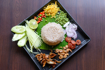 Thai food - Rice mixed with shrimp paste (Kao Cluk Ka Pi) with side dish as a mango, lemon, chili, cucumber, scrambled egg, cow-pea, shallots, Chinese sausage, dried shrimp and pork