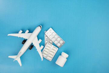 pharmaceutical shipping, medical international air drug delivery, medicine and pills with plane on blue background