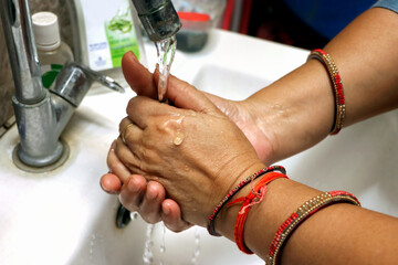 Cropped Image Of an asian Woman Washing Hands In Sink At Home. Selective focus