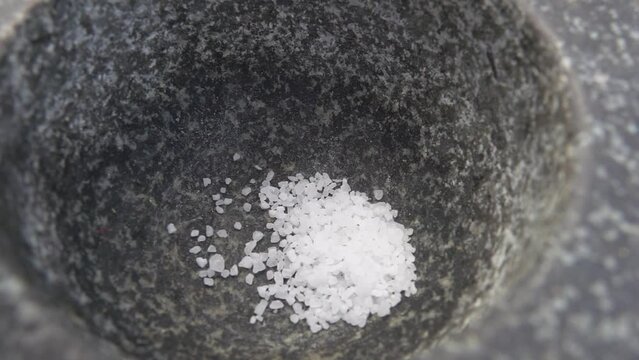 Sea salt is poured into a mortar