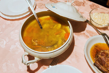 Formal lunch in a European/Balkan domestic household, roasted pork and homemade chicken soup 
