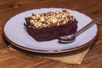 Piece of chocolate cake brownie and a spoon. Calories in a piece of chocolate cake