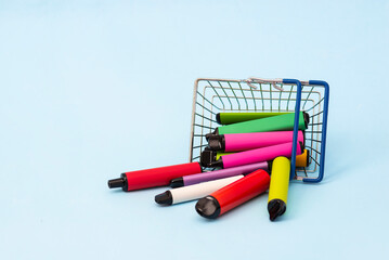A set of multi-colored sticks - disposable vaping devices, electronic cigarettes in a shopping...