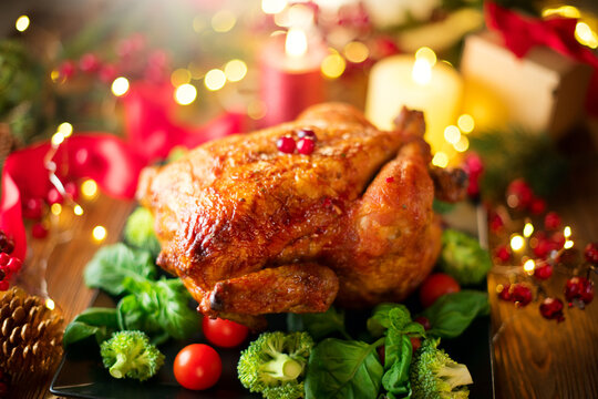 Christmas, Thanksgiving Dinner. Roasted chicken. Winter Holiday table served, decorated with candles and xmas baubles. Roast turkey , table setting family dinner with gifts