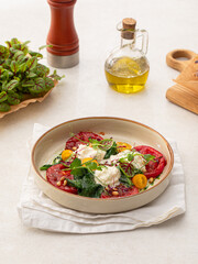 Portion of grilled tomatoes and stracciatella cheese