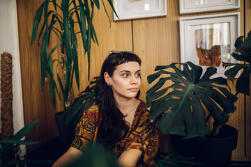 Fashionable young woman taking care of her house plants