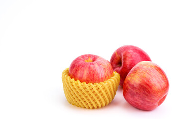 A red apple wrapped in a foam net or bubble wrap. to prevent business damage during transportation isolated on white background