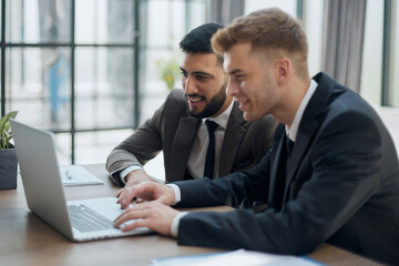 Fototapeta premium two professional businessmen discussing and using desktop computer in office