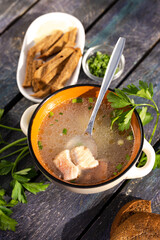 top view of fish soup ear with croutons and parsley on a blue wooden background