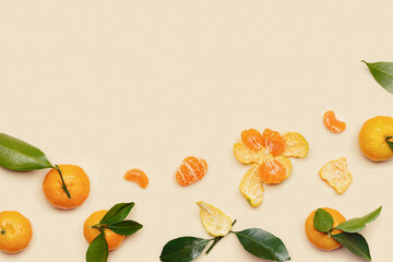 Orange yellow juicy tangerines with green leaves, whole and peeled on neutral beige background with copy space. Citrus fruits mandarins, healthy fruits food concept, creative styled photo