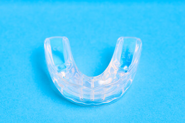 LM Activator individual activator and aligner for orthodontic treatment correcting deep bite, distal bite, mild open bite, and incorrect tongue position isolated over blue background.