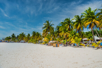 Obraz na płótnie Canvas ISLA MUJERES ISLAND, MEXICO - APR 2022: Cocos beach bar on a beach with white sand and palms on a sunny day, Isla Mujeres island, Caribbean Sea, Cancun, Yucatan, Mexico