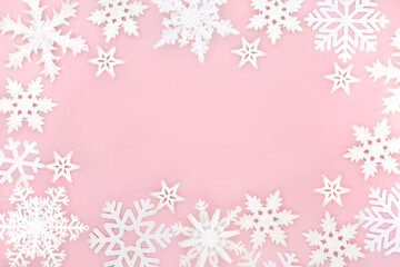 Festive Christmas magical ornate snowflake background on pastel pink. Fantasy design for winter, Xmas, New Year holiday season.