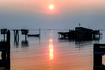 Fototapeta premium Pellestrina, Venezia. Casoni da pesca al tramonto