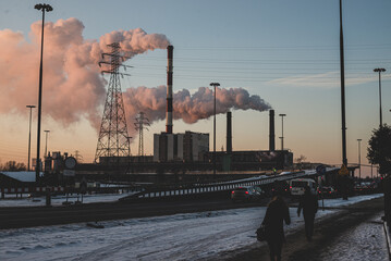 power station at sunset in the big city, with smoke coming out from the chimneys. © malgo_walko