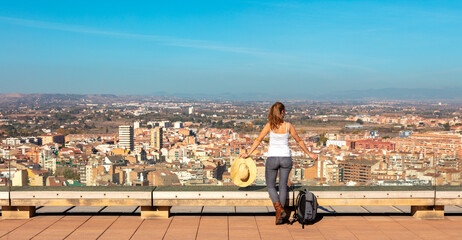 Panorama of city landscape in Catalonia,  Woman with backpacklooking at panoramic Lerida city view