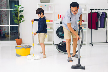 Father teaching asian kid little boy son having fun doing household chores cleaning and washing floor wiping dust with vacuum cleaner while cleaning house together at home.Housework concept