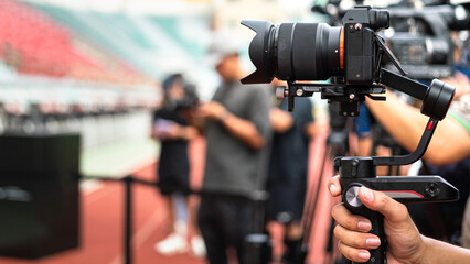 Action of the cameraman is holding the camera on gimbal to recording footage in the press...