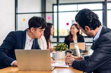 Group of asian business meeting and discussing strategy startup project analysis finance process.Success business people work plan and brainstorm marketing idea with laptop in office.Teamwork