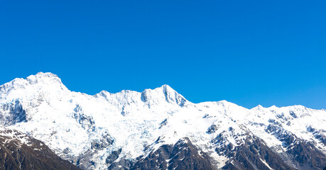 The mountain view of alpine as snow-capped mount peaks in  Swiss Mountain alps against the blue sky background