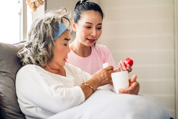 Obraz na płótnie Canvas Portrait of love asian family senior mature mother and woman daughter care holding bottle tablet with pill and taking medicine with glass of water together.Healthcare senior people concept