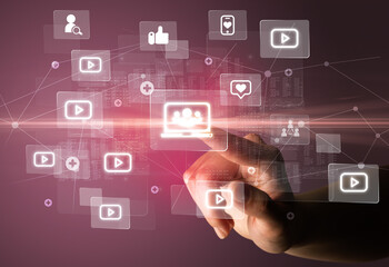Hand pressing social media multimedia application screen with media icons on futuristic concept