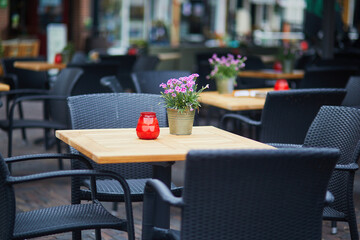 Wooden table decorated with flower pot, candles and lantern in outdoor cafe in Alkmaar