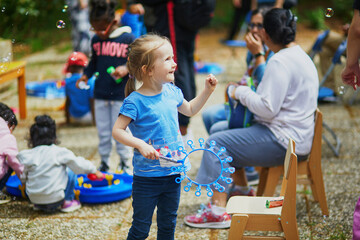 preschooler girl having fun blowing bubbles