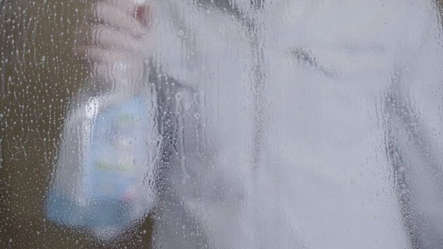 Washing the windows with cleaning spray