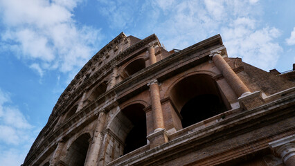 Colesseum on the white cloudy and blue or azure sky background, bottom view or from below.