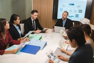 Serious diverse business team leader discuss financial paperwork, Smart businessman and businesswoman partner teamwork talking discussion in group meeting at office table in modern office interior
