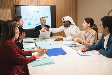 Emirate man person having business deal agreements with partnership team, Arabian manager making handshake with businessman corporate group on table at office room, talk with Arab company from Dubai