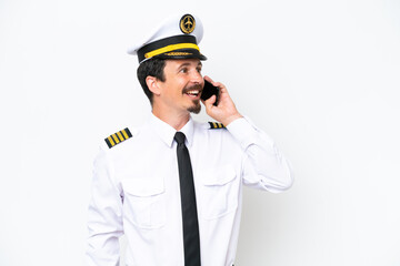 Airplane caucasian pilot isolated on white background keeping a conversation with the mobile phone