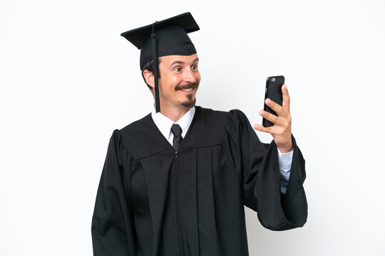 Young university graduate man isolated on white background making a selfie