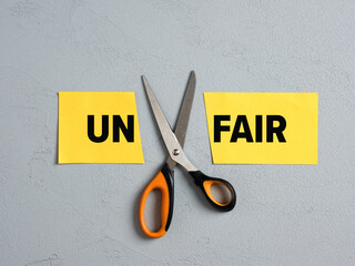 Scissors Cutting off the Word Un of Unfair. Concept of fairness, equity, justice and integrity.